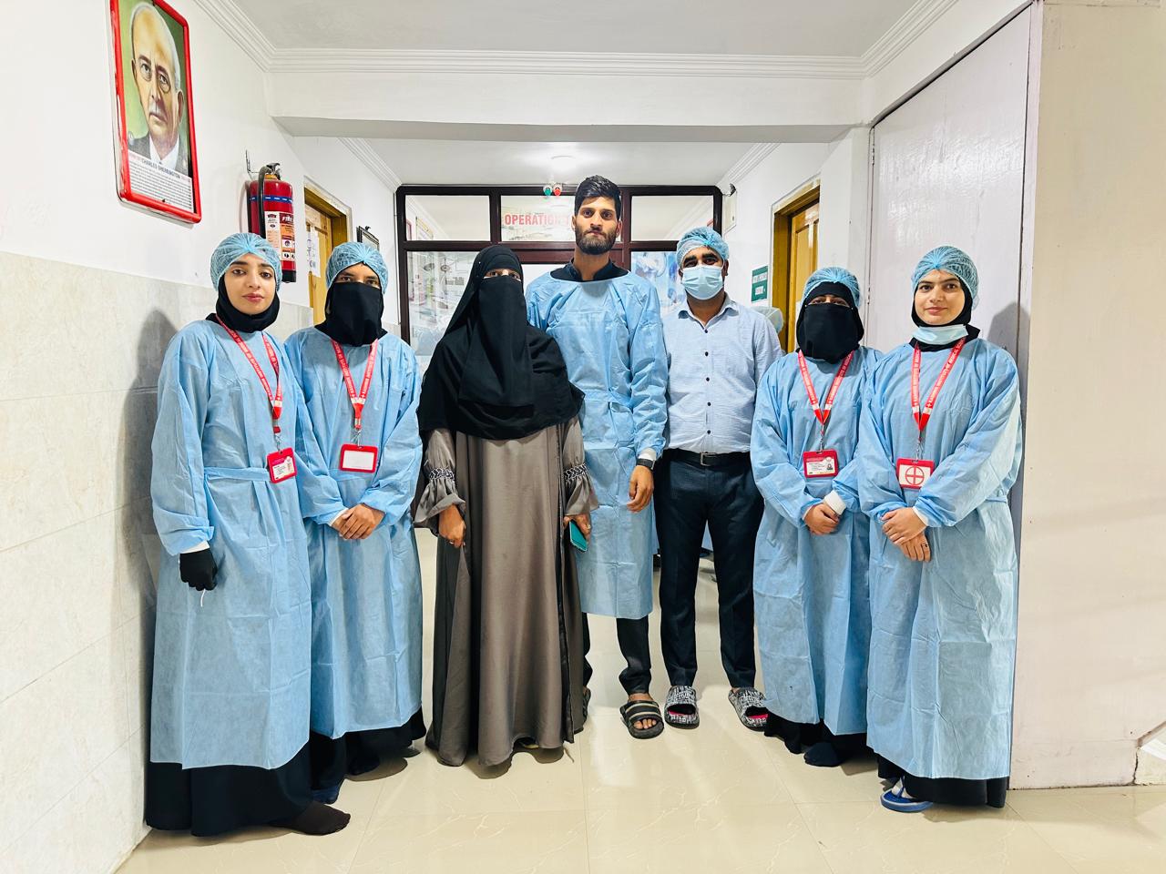 KIMST students in surgical gowns and caps standing together in a hospital corridor